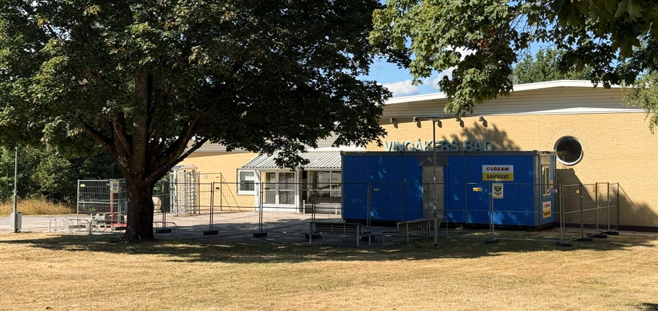 Entrén till Vingåkers badhus med byggstängsel och etableringsbod inför renoveringsarbetet.